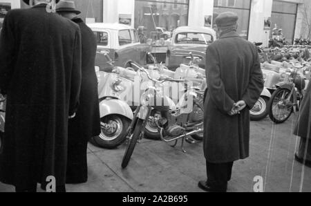 Die Stadt während der Frühjahrsmesse 1960. Kunden im Verkaufsraum eines Autohändlers. BehindTrabant P50 Universal (links) und Sedan, Zentrum IWL SR59 Berlin, vor Simson SR1. Stockfoto