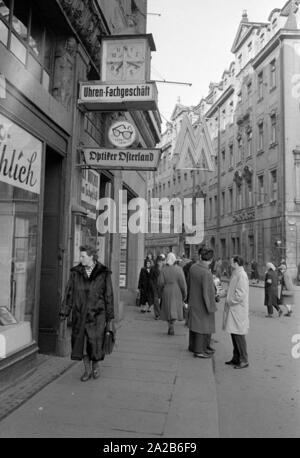 Straßenszene in Leipzig während der Frühjahrsmesse 1960. Über dem Bürgersteig das Logo der Messe (1 M). Stockfoto