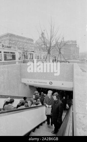 Eingang und Ausgang der unteren Ebene am Stachus, das an die S-Bahn und Shopping Center führt. Dahinter ist eine Straßenbahn mit Werbung für die Fluggesellschaft Trans World Airlines (TWA). Im Hintergrund links, das Hotel Königshof (Die Vier Jahreszeiten) und auf der rechten Seite der Palast der Justiz. Stockfoto