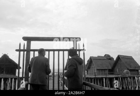 Zwei Menschen stehen vor dem Eingang zum pile-wohnung Dorf am Bodensee. Das Bild zeigt das Freilichtmuseum Unteruhldingen, früher 'Museum deutscher Vorzeit' (Museum für Deutsche Vorgeschichte). Stockfoto