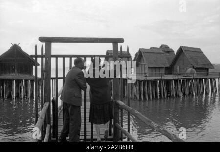 Zwei Menschen stehen vor dem Eingang zum pile-wohnung Dorf am Bodensee. Das Bild zeigt das Freilichtmuseum Unteruhldingen, früher 'Museum deutscher Vorzeit' (Museum für Deutsche Vorgeschichte). Stockfoto