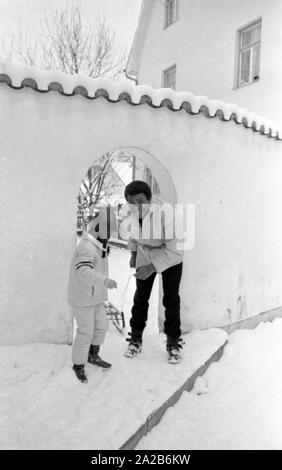 Roberto Blanco spielt im Schnee mit seiner Tochter Mercedes und einem Schlitten im Jahre 1970. Stockfoto