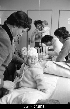 Mütter mit ihren Kindern im Kindergarten in Rimbach. Die dorfgemeinschaft Häuser wurden als Teil der Hessenplan unter anderem gebaut, um die Infrastruktur und das kulturelle Leben in ländlichen Gebieten zu verbessern. Stockfoto