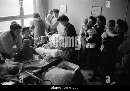 Mütter mit ihren Kindern im Kindergarten in Rimbach. Die dorfgemeinschaft Häuser wurden als Teil der Hessenplan unter anderem gebaut, um die Infrastruktur und das kulturelle Leben in ländlichen Gebieten zu verbessern. Stockfoto