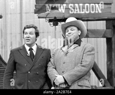 Der Imitator von Hoss aus Bonanza, Dan Blocker mit Wim Thoelke vor einem der aloon' Hintergrund mit der Aufschrift 'Limousine' auf der 3x9-TV-Show. Stockfoto