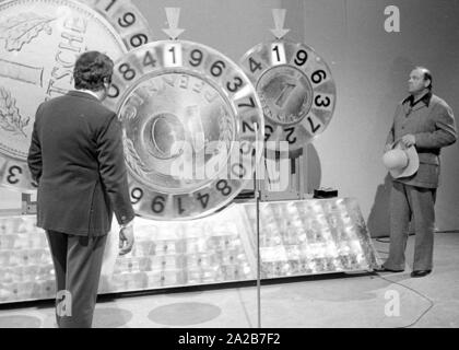 Wim Thoelke und der Imitator von Hoss aus der Fernsehserie Bonanza, Dan Blocker, in der Fernsehsendung 3x9. Die glücklichen Räder in Form der Deutschen Mark und des Pfenning sind die Symbole der Aktion Sorgenkind. Stockfoto