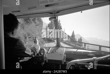 Zwei Busse treffen sich auf der schmalen Kehlsteinstrasse zum und vom Kehlsteinhaus (Eagle's Nest). Das Bild zeigt, wie die Busfahrer über Handzeichen verständigen. Stockfoto