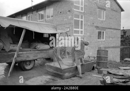 Zwei Bauarbeiter Mix Zement an der Baustelle eines neuen Wohnhauses in Tuttlingen. Stockfoto