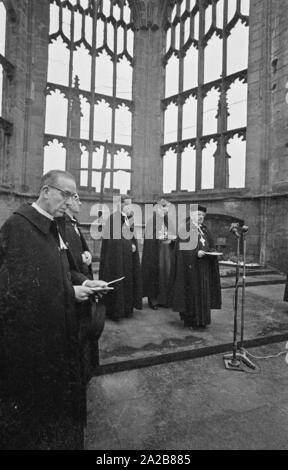 Der deutsche Bischof Otto Dibelius, gibt eine Rede, in der Ruine der Kathedrale von Coventry (Kathedrale Kirche des Hl. Michael) anlässlich der Grundsteinlegung für das "Internationale Zentrum für Versöhnung" an der gleichen Stelle. Hinter ihm auf der linken Seite, Reverend Bill Williams, der Pastor von conventry. Im Hintergrund auf dem Altar, dem Verkohlten Kreuz und das Kreuz der Nägel. Stockfoto