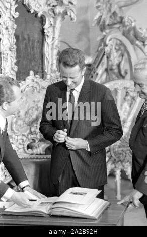 Ende April 1971 hat die belgische Königspaar besucht München. Im Bild: König Baudouin Zeichen ein Gästebuch. Stockfoto