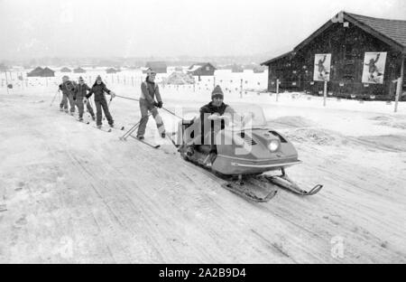 Kinder in den Skikurs in der Skischule Garmisch. Die Firma "Marker" wirbt für seine Sicherheit Skibindungen mit Transparenten und Plakaten. Stockfoto