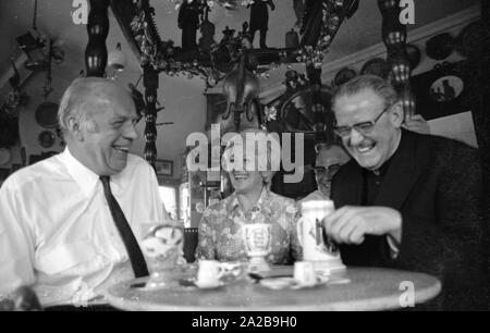 Die folk Schauspieler Beppo Brehm (li.) und Erni Singerl (Mitte) gemeinsam mit der Stadt Pfarrer (r.) in der Turmstueberl des Valentin-Karlstadt-Musaeum in München. Stockfoto