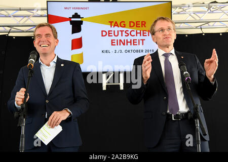 02. Oktober 2019, Schleswig-Holstein, Kiel: Daniel Günther (CDU, r), Ministerpräsident von Schleswig-Holstein, und Ulf Kämpfer (SPD), Oberbürgermeister von Kiel, wird auf der Bühne bei der Eröffnung der Bürgerfest werden während der Feierlichkeiten zum Tag der Deutschen Einheit. Die Feierlichkeiten rund um den 3. Oktober wird gehostet von Schleswig-Holstein in diesem Jahr. Foto: Carsten Rehder/dpa Stockfoto