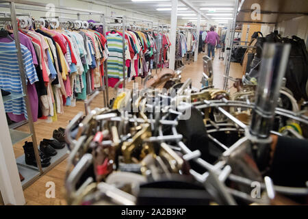 Greifswald, Deutschland. 01 Okt, 2019. Gebrauchte Kleidung hängt an einen Verkaufsstand im sozialen Kaufhaus Greifswald. Die Institution bietet Second-Hand-Möbel, Elektrogeräte, Kleidung, Schuhe oder Bücher zum Verkauf an die Bürger. Quelle: Stefan Sauer/dpa-Zentralbild/dpa/Alamy leben Nachrichten Stockfoto