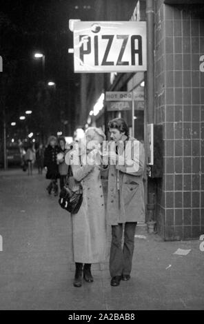 A couple shares a piece of pizza. Stockfoto