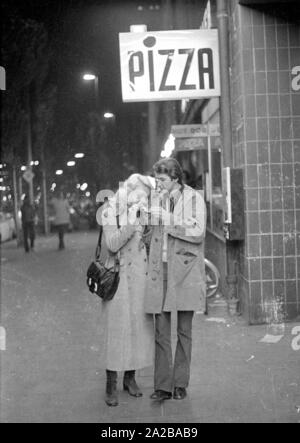 A couple shares a piece of pizza. Stockfoto