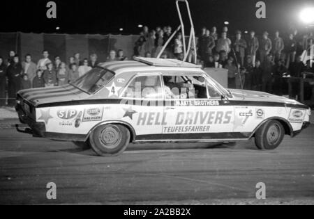 Show der "Hell Drivers - Teufelsfahrer' im Jahr 1974, in dem Stuntmen insgesamt alte Autos und spektakuläre Akrobatik durchführen. Hier ist ein Auto mit dem Logo der Gruppe. Stockfoto