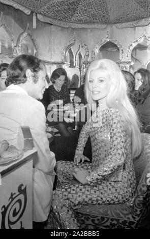 Blonde Frau in einem glitzernden zweiteilige Suite an der Eröffnung der Diskothek '1001 Nacht'. Stockfoto