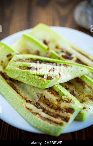 Gegrillte Zucchini mit Zwiebeln in einem Teller, auf einen Tisch. Stockfoto