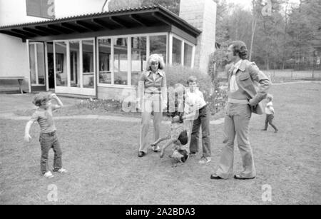 Home Geschichte mit dem Beckenbauer Familie. Im Bild: Die Beckenbauer Familie spielt im Garten mit dem Hund, von Links nach Rechts: Stephan, Brigitte Beckebauer, Thomas, Michael (hinter) und Franz Beckenbauer. Stockfoto