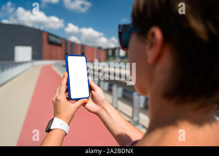 Frau mit Smartphone mit leeren Bildschirm. Vorlage, Mockup, Design. Stockfoto