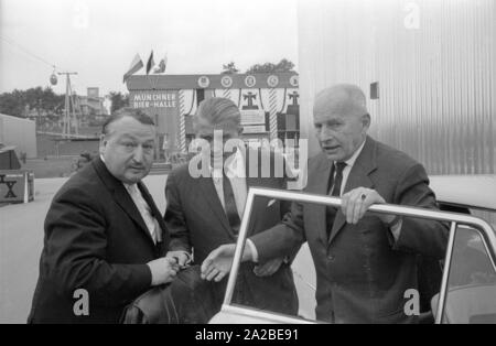 Ingenieur Wernher von Braun (Mitte) besucht den internationalen Transport Ausstellung (IVA) auf der Theresienhöhe in München. Die Seilbahn im Hintergrund ist auch Teil des IVA. Stockfoto