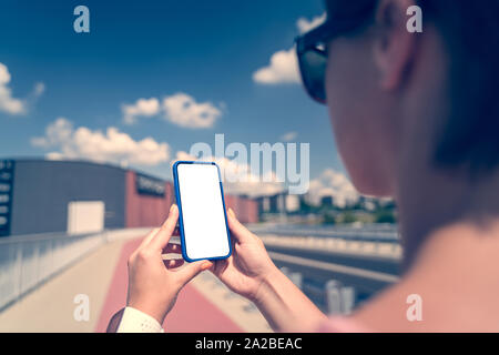 Frau mit Smartphone mit leeren Bildschirm. Vorlage, Mockup, Design. Stockfoto