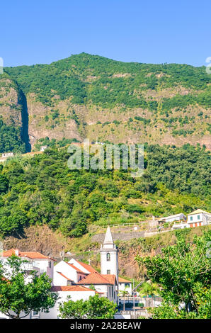 Schöne Bergdorf in Sao Vicente Madeira, Portugal. Die kleine Stadt ist von grünen Hügeln umgeben. Terrassierten Feldern, Felsen, hügelige Landschaft. Portugiesische Insel im Atlantischen Ozean. Stockfoto