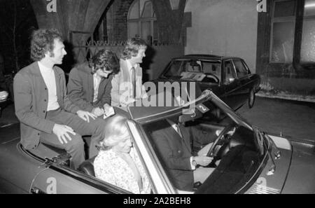 FC Bayern feiert den Gewinn der Bundesliga Meisterschaft und den Europapokal der Meister. Von links: Franz Beckenbauer, Gerd Müller und Torwart Sepp Maier. Brigitte Beckenbauer sitzt im Beifahrersitz. Stockfoto