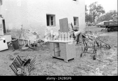 Reinigung nach einem schweren Sturm in einem Dorf am Chiemsee. Die frisierkommode ist bereits gereinigt. Stockfoto