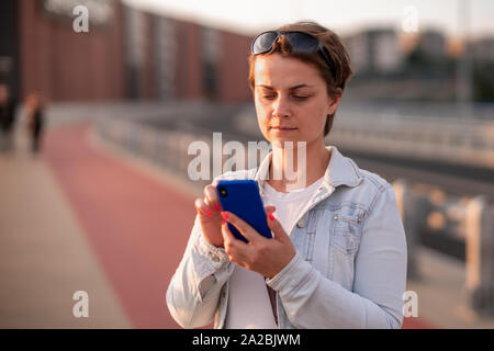 Frau mit Smartphone mit leeren Bildschirm. Vorlage, Mockup, Design. Stockfoto