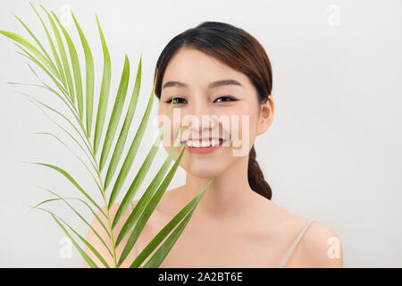 Schöne Frau mit asiatischem Aussehen palm leaf Nature Skin Care Stockfoto