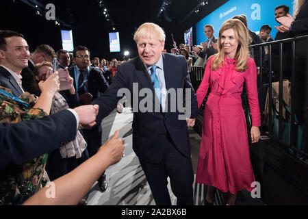 Premierminister Boris Johnson verlässt die Bühne mit seinem Partner Carrie Symonds nach seiner Rede auf dem Parteitag der Konservativen Partei in der Manchester Convention Center. Stockfoto