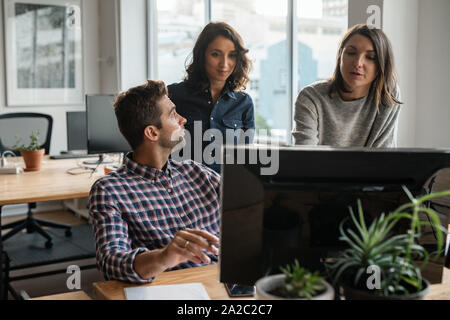 Gruppe von verschiedenen jungen Designern gemeinsam auf einem Computer Stockfoto