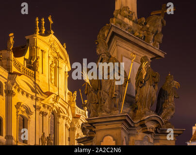 Prag - Die barocke Säule der Heiligen Dreifaltigkeit und Turm und Fassade der St. Nichlas Kirche bei Nacht. Stockfoto