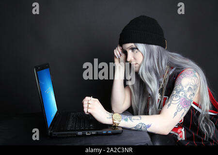Seitenansicht des tausendjährigen Frau auf Laptop mit Microsoft Windows 7 Updates auf Bildschirm durchgeführt werden suchen, Low Key 2019 Stockfoto