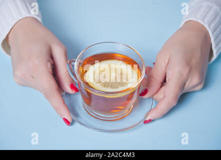 Frau mit Tasse Tee mit Zitrone. Stockfoto