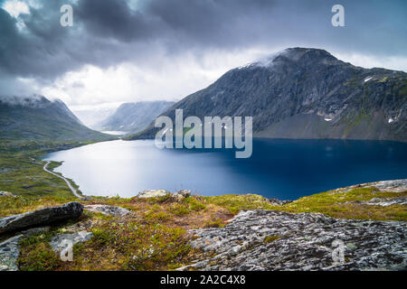 Blick auf den See zwischen norwegischen Fjorde und Berge mit einem grünen Gras, blaues Wasser und bewölkter Himmel Stockfoto