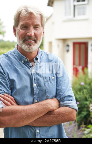 Portrait von reifer Mann im Garten Vor der Traumhaus auf dem Land Stockfoto