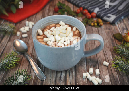 Becher mit heißer Schokolade garniert mit kleinen weißen Marshmallows und Chocolate und Cinnamon Pulver Stockfoto