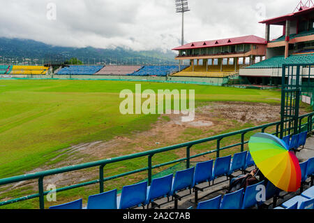 Bunten Regenschirm auf den Sitz der Dharamshala himachal Cricket Stadion Stockfoto