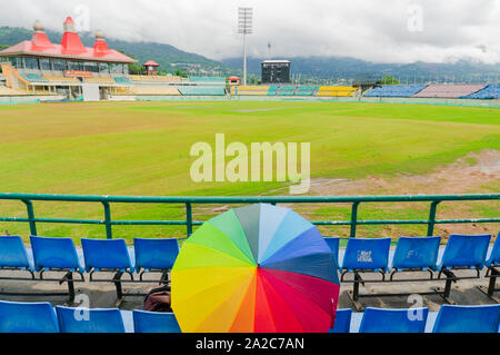 Bunten Regenschirm auf den Sitz der Dharamshala himachal Cricket Stadion Stockfoto