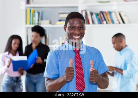Erfolgreiche afrikanische amerikanische Geschäftsmann mit Krawatte und Kollegen im Büro Stockfoto