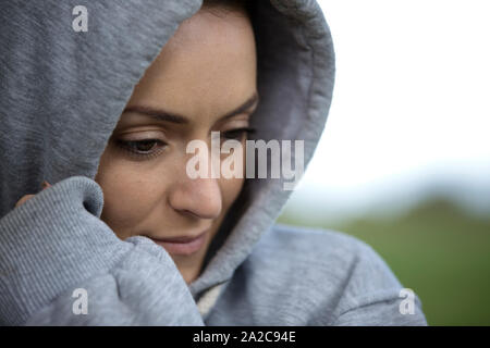 Junge Frau an einem kalten Morgen in ein Kapuzenshirt vor dem ausgehen für einen Lauf Stockfoto