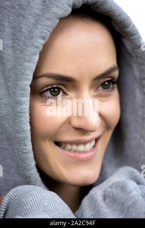 Junge Frau an einem kalten Morgen in ein Kapuzenshirt vor dem ausgehen für einen Lauf Stockfoto