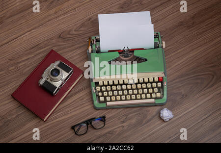 Schreibmaschine Auf der alten hölzernen Schreibtisch mit Zerknüllten Papiere Stockfoto