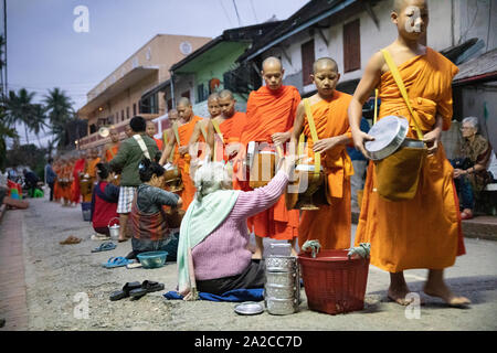 Tak Bat Mönche zu Almosen in der Morgendämmerung, Luang Prabang, Provinz Luang Prabang Laos, Laos, Südostasien Stockfoto