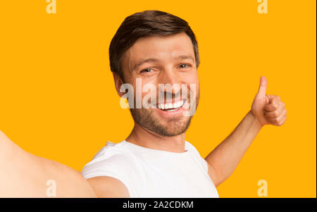 Mann unter Selfie Gestik Daumen hoch, Studio Shot Stockfoto