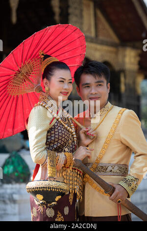 Junges Paar für Hochzeit Foto posiert in traditioneller Kleidung außerhalb Wat Xiengthong, Luang Prabang, Provinz Luang Prabang Laos, Laos, Southea Stockfoto