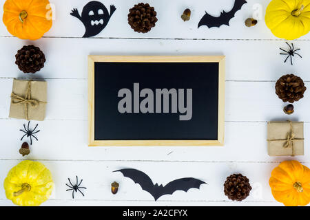 Halloween Urlaub Hintergrund mit orange Kürbis, Geist, Spinne, bat und Schwarz auf Weiß Holztisch mit Platz für Text kopieren. Flach, oben vie Stockfoto
